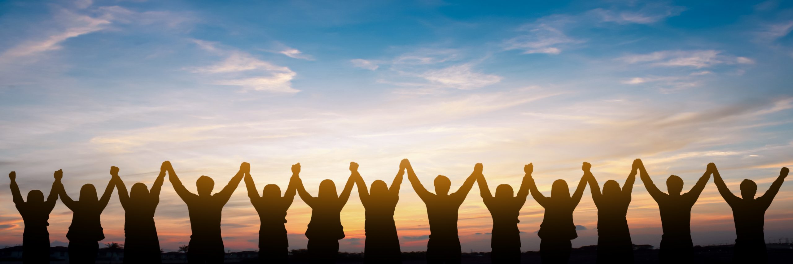 Silhouette of group happy business team making high hands over head in beautiful sunset sky evening time for business success and teamwork concept in company
